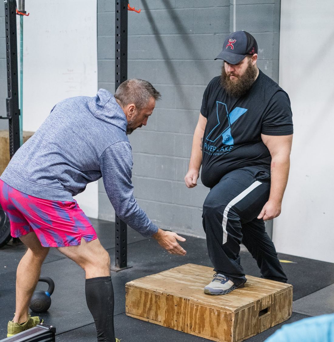 Kevin coaching a client through a box step-up, hand cueing form
