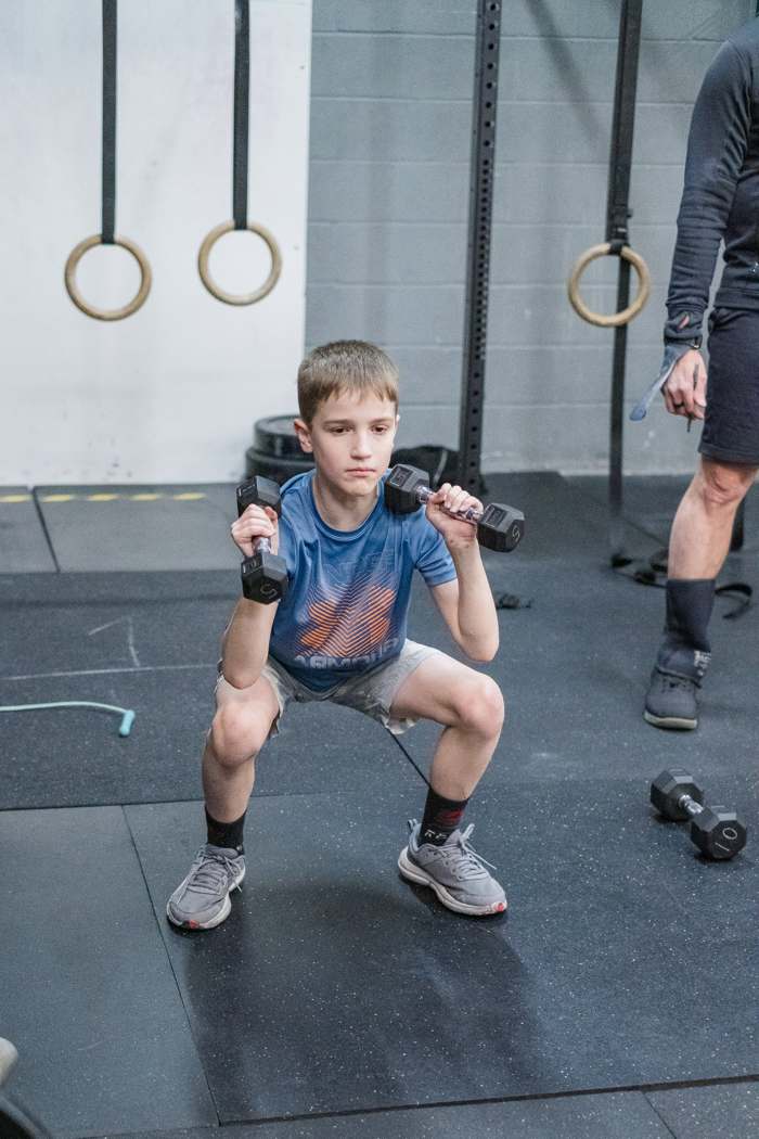 RNF CrossFit Kids member doing a squat